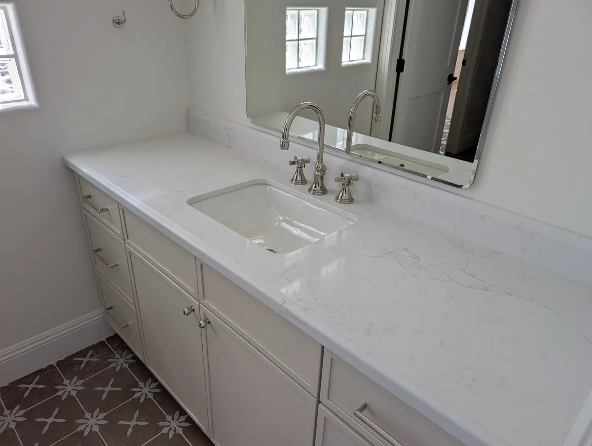 Long marble vanity with chrome bridge faucet, Prescott primary bathroom