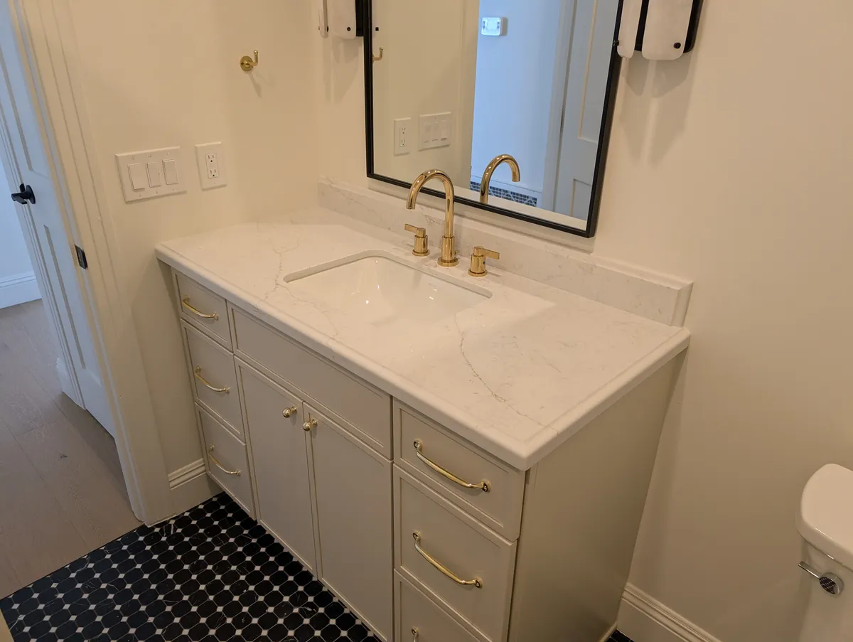 Powder room with brass widespread faucet and quartz countertop, Prescott