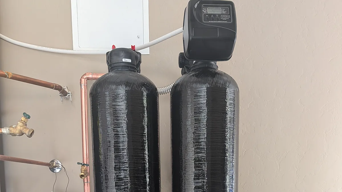 Two-tank whole-house water treatment system with an electronic control valve, plumbed in copper, garage installation