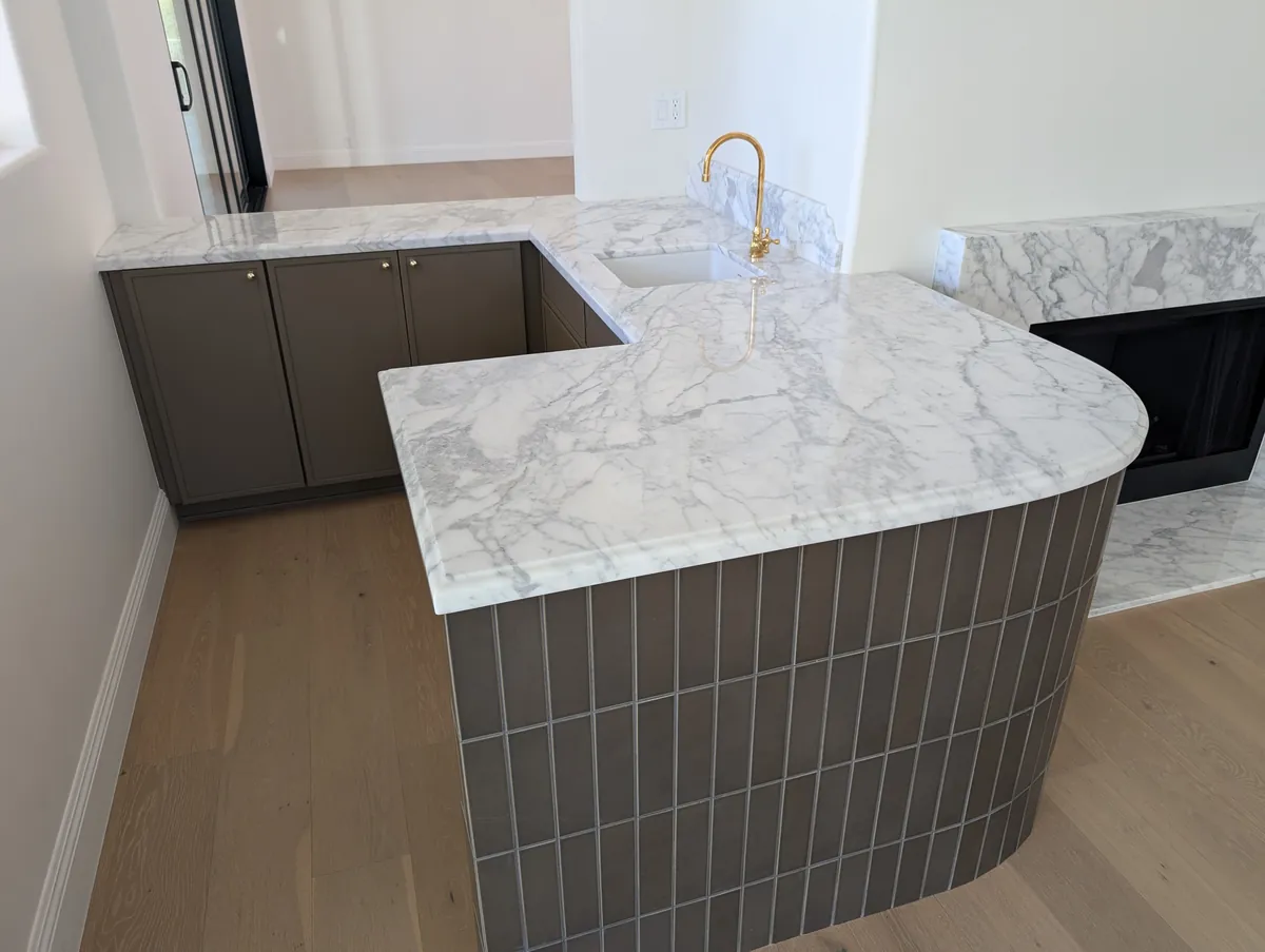 Wet bar with marble countertop, brass gooseneck faucet, and curved tile base, Prescott estate